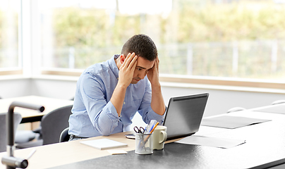 Image showing stressed man with laptop working at home office