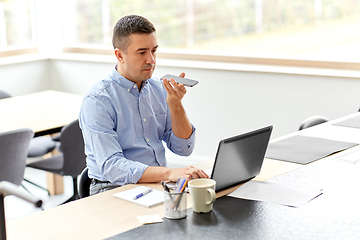 Image showing man with smartphone and laptop at home office