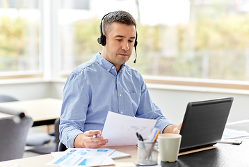 Image showing man with headset and laptop working at home