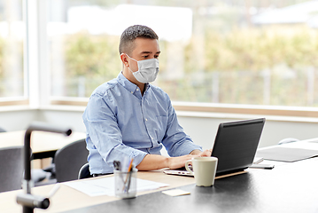 Image showing man in mask with laptop working at home office