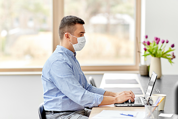 Image showing man in mask with laptop working at home office