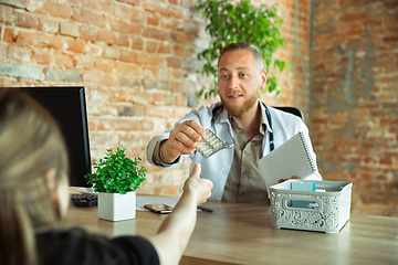 Image showing Caucasian doctor consulting for patient, explaining recipe for drug, working in cabinet