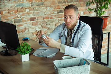 Image showing Caucasian doctor consulting for patient, explaining recipe for drug, working in cabinet