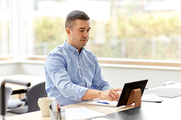 Image showing man with tablet computer working at home office