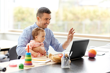 Image showing father with baby working on laptop at home office