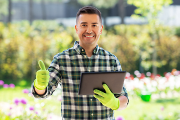 Image showing man with tablet pc showing thumbs up at garden