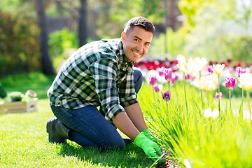 Image showing happy man taking care of flowers at garden
