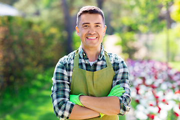 Image showing happy man in apron at summer garden