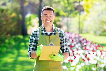 Image showing happy man with clipboard at summer garden