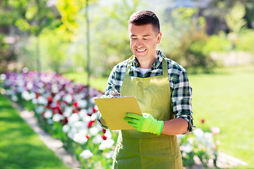 Image showing happy man with clipboard at summer garden