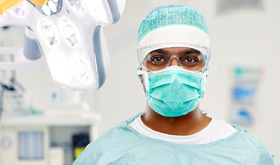 Image showing indian male surgeon in mask over operating room