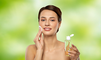 Image showing young woman with toner or cleanser and cotton pad