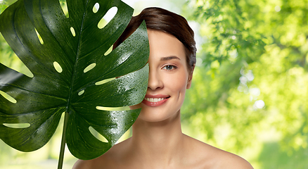 Image showing beautiful young woman with green monstera leaf
