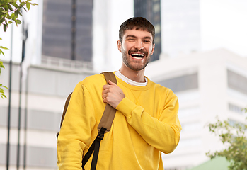 Image showing happy smiling young man with backpack in city