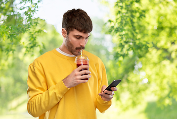 Image showing man with smartphone and tomato juice