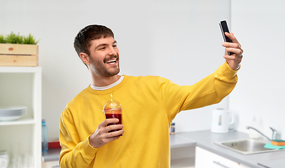 Image showing happy man with smartphone and juice taking selfie