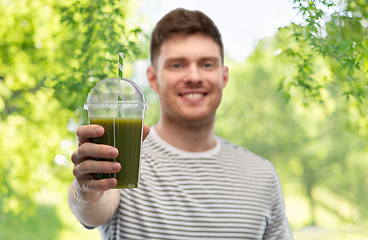 Image showing man drinking green smoothie from disposable cup