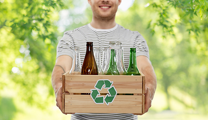 Image showing smiling young man sorting glass waste