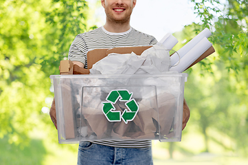 Image showing smiling young man sorting paper waste