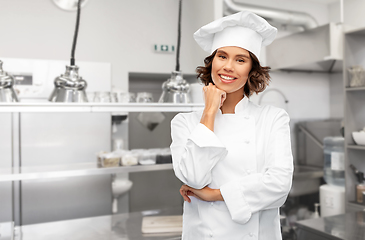 Image showing smiling female chef in toque over restaurant