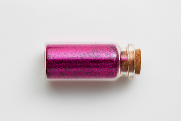 Image showing pink glitters in bottle over white background