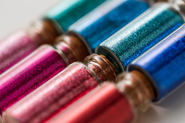 Image showing set of glitters in bottles over white background