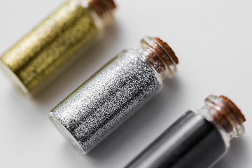 Image showing set of glitters in bottles over white background