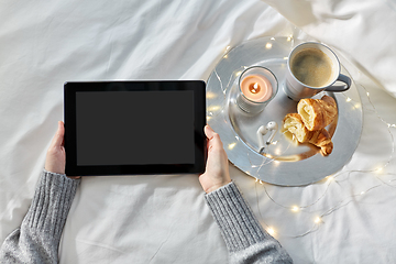 Image showing hands with tablet pc, croissant and coffee in bed