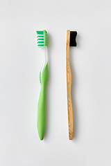 Image showing wooden and plastic toothbrush on white background