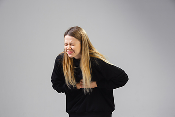 Image showing Young woman suffers from pain, feels sick, ill and weakness isolted on studio background