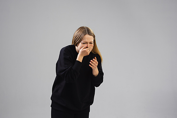 Image showing Young woman suffers from pain, feels sick, ill and weakness isolted on studio background