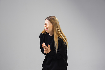 Image showing Young woman suffers from pain, feels sick, ill and weakness isolted on studio background