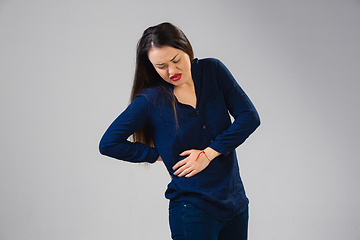 Image showing Young woman suffers from pain, feels sick, ill and weakness isolted on studio background