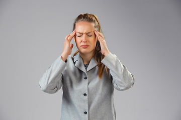 Image showing Young woman suffers from pain, feels sick, ill and weakness isolted on studio background