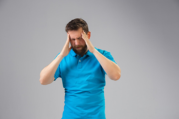 Image showing Young man suffers from pain, feels sick, ill and weakness isolted on studio background