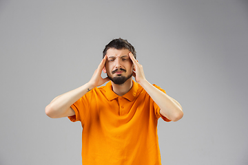 Image showing Young man suffers from pain, feels sick, ill and weakness isolted on studio background