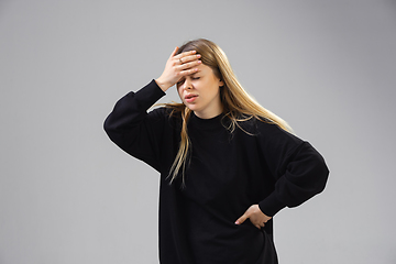 Image showing Young woman suffers from pain, feels sick, ill and weakness isolted on studio background