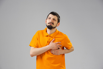 Image showing Young man suffers from pain, feels sick, ill and weakness isolted on studio background