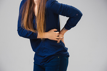 Image showing Young woman suffers from pain, feels sick, ill and weakness isolted on studio background