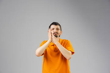 Image showing Young man suffers from pain, feels sick, ill and weakness isolted on studio background