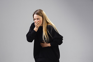 Image showing Young woman suffers from nausea, feels sick, ill and weakness isolted on studio background