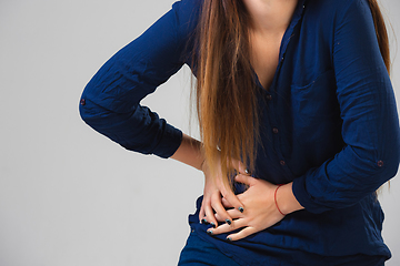 Image showing Young woman suffers from pain, feels sick, ill and weakness isolted on studio background