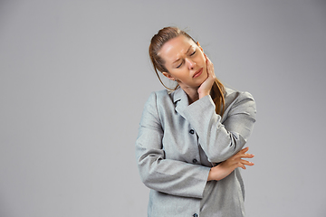 Image showing Young woman suffers from pain, feels sick, ill and weakness isolted on studio background