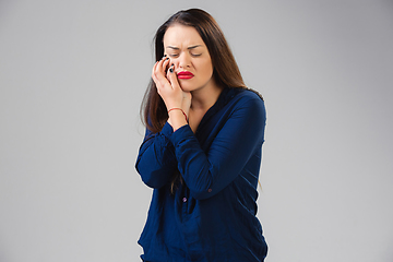 Image showing Young woman suffers from pain, feels sick, ill and weakness isolted on studio background