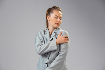 Image showing Young woman suffers from pain, feels sick, ill and weakness isolted on studio background