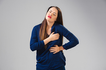 Image showing Young woman suffers from pain, feels sick, ill and weakness isolted on studio background