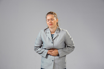 Image showing Young woman suffers from pain, feels sick, ill and weakness isolted on studio background