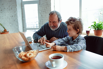 Image showing Grandfather and his grandson spending time insulated at home, stadying, watching cinema, shopping together