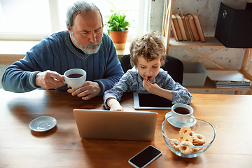 Image showing Grandfather and his grandson spending time insulated at home, stadying, watching cinema, shopping together