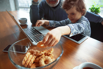 Image showing Grandfather and his grandson spending time insulated at home, stadying, watching cinema, shopping together